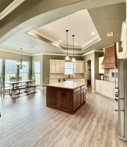 a large kitchen with stainless steel appliances kitchen island granite countertop a sink counter space and wooden floor