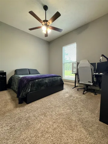 a bedroom with a bed window and a ceiling fan
