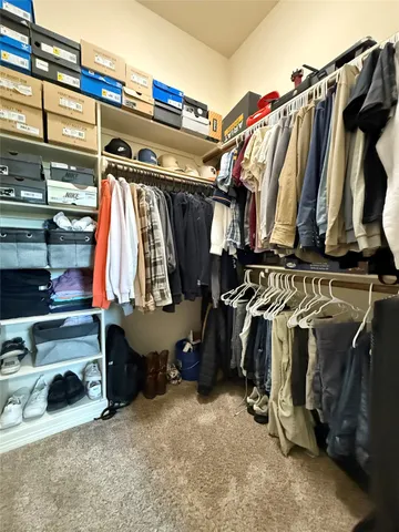 a view of walk in closet with clothes and shoes