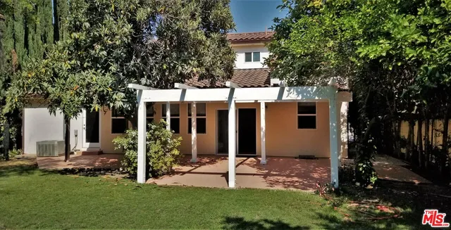a view of a house with backyard and a tree
