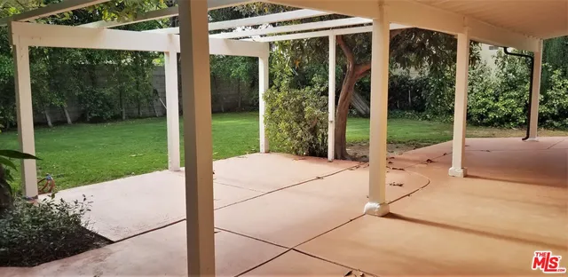 a view of a house with backyard and a tree