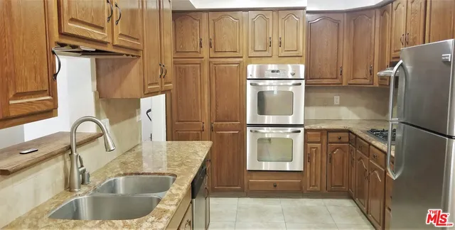 a kitchen with stainless steel appliances granite countertop a refrigerator and a sink