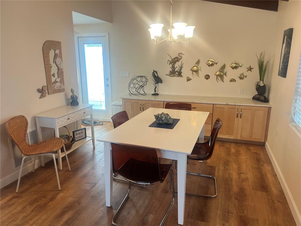 6020 Midnight Pass Road, Unit 38 Sarasota, FL 34242 - Photo 5 of 11 a view of a dining room with furniture and wooden floor