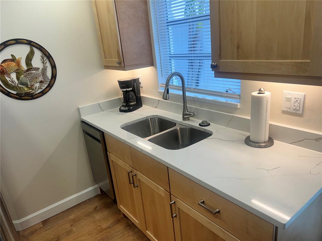 6020 Midnight Pass Road, Unit 38 Sarasota, FL 34242 - Photo 7 of 11 a kitchen with a sink and a refrigerator