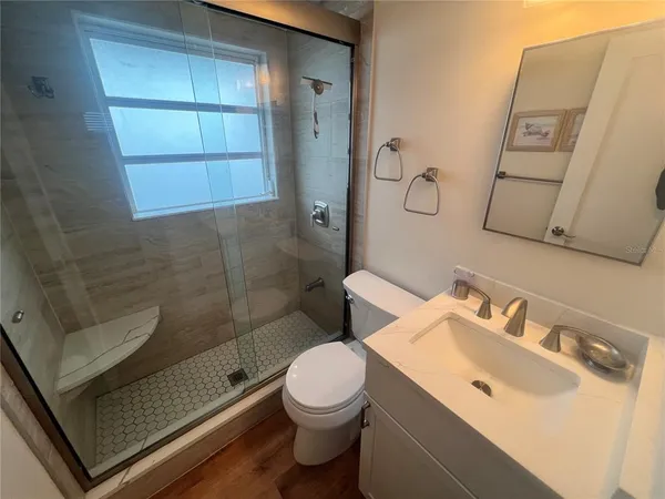 a bathroom with a sink a toilet and shower