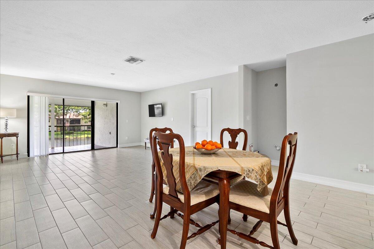 21719 Arriba Real, Unit J Boca Raton, FL 33433 - Photo 12 of 33 a view of a dining room with furniture and wooden floor