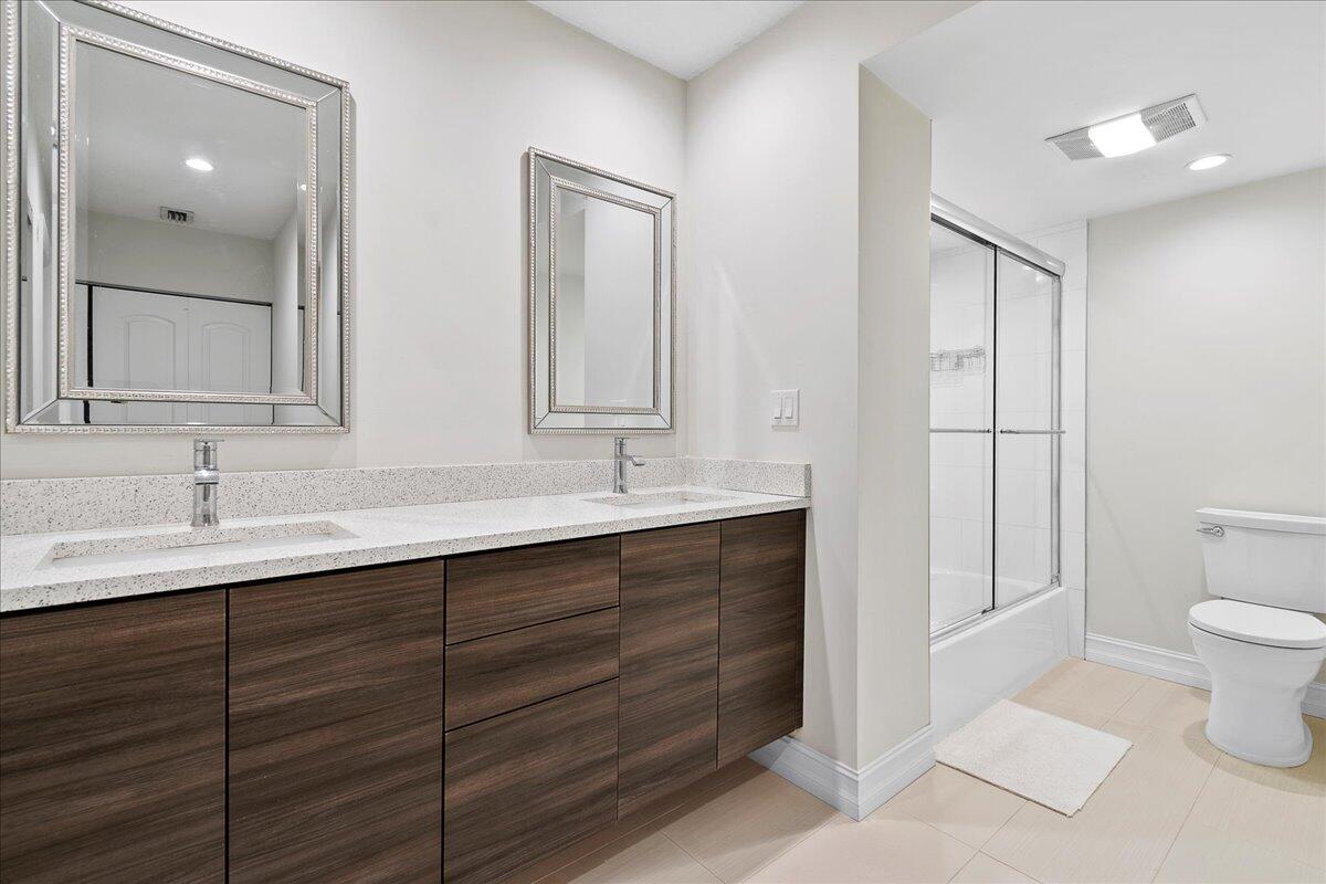 21719 Arriba Real, Unit J Boca Raton, FL 33433 - Photo 15 of 33 a bathroom with a toilet sink and mirror