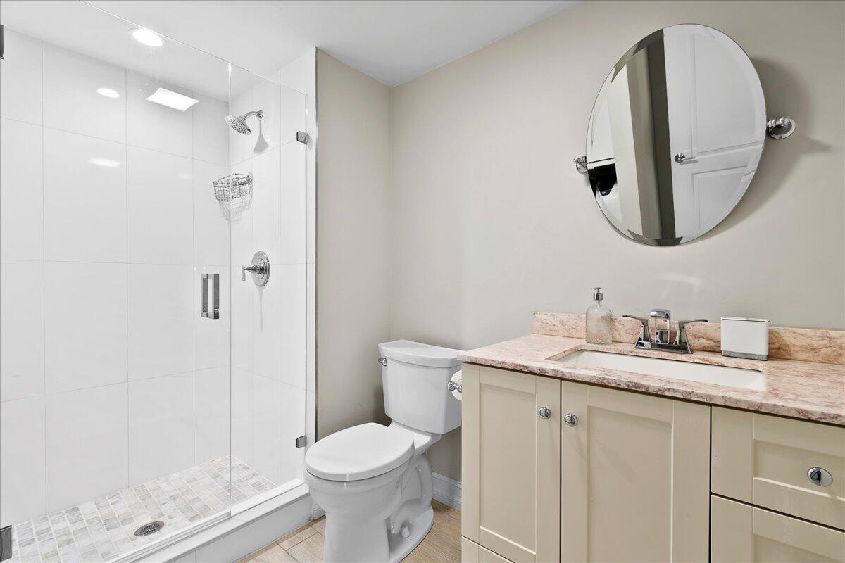 21719 Arriba Real, Unit J Boca Raton, FL 33433 - Photo 19 of 33 a bathroom with a granite countertop sink a toilet and a mirror