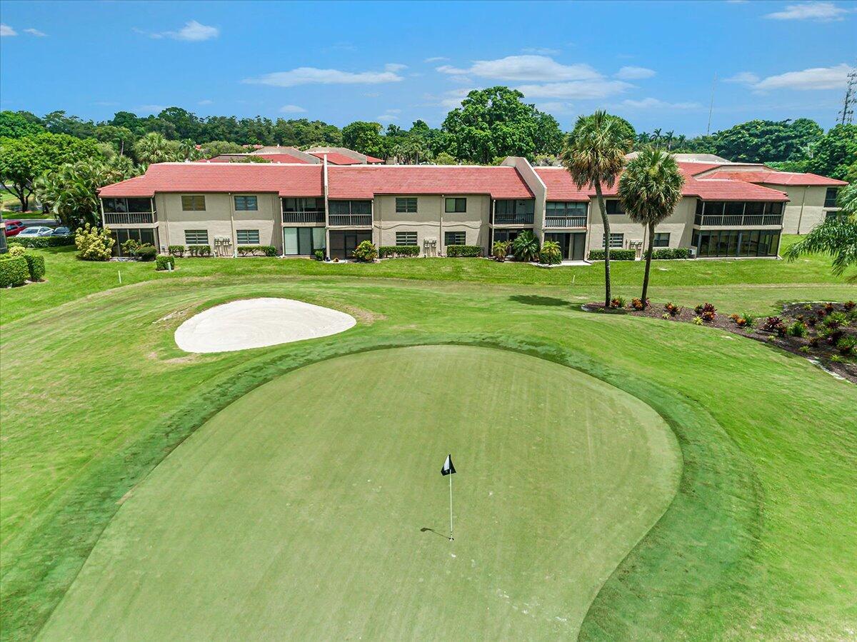 21719 Arriba Real, Unit J Boca Raton, FL 33433 - Photo 28 of 33 a view of a swimming pool with lawn chairs under an umbrella