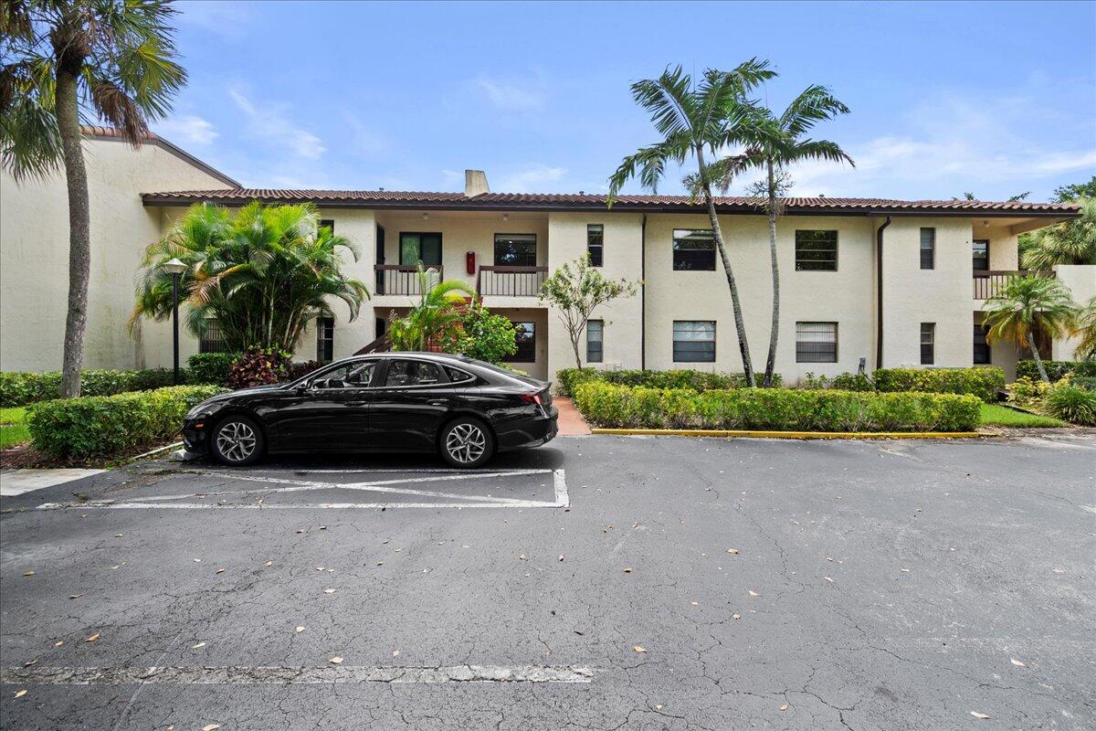 21719 Arriba Real, Unit J Boca Raton, FL 33433 - Photo 30 of 33 a front view of a house with a garden