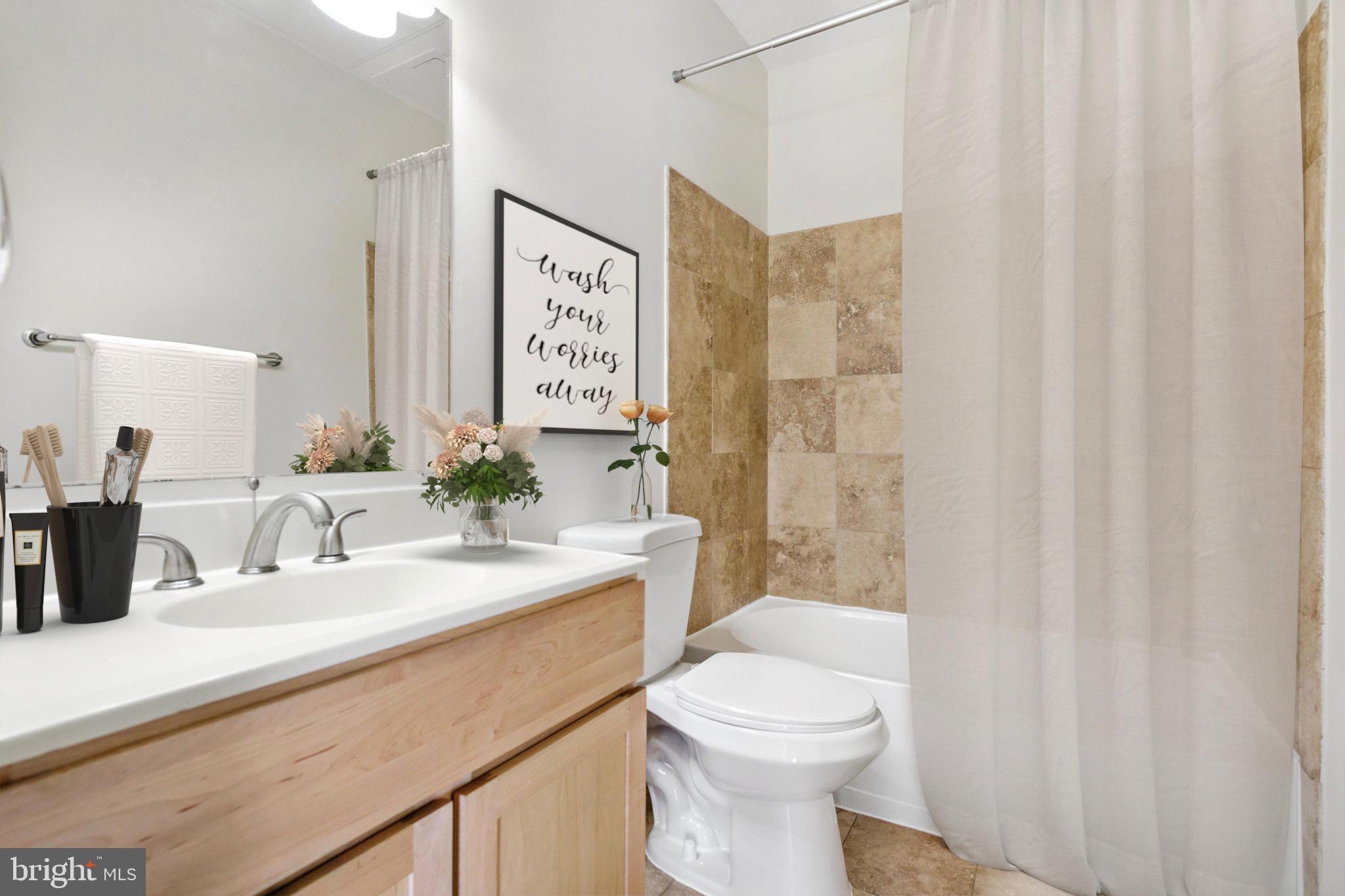 5885 Colorado Avenue Northwest, Unit 208 Washington, DC 20011 - Photo 17 of 27 a bathroom with a sink a toilet and shower curtain