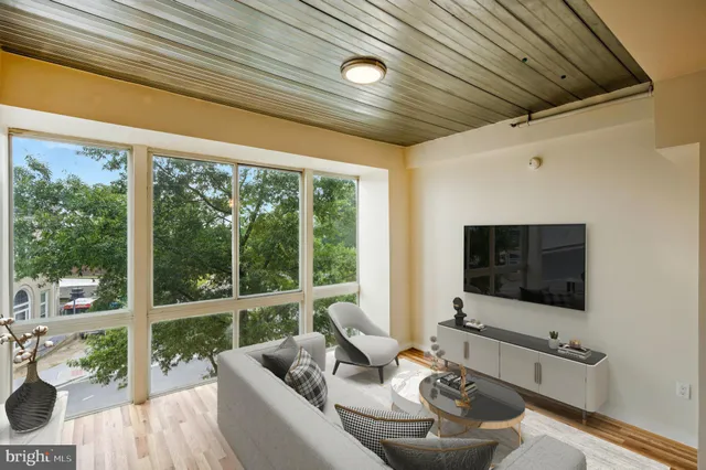 a living room with furniture tv and a large window