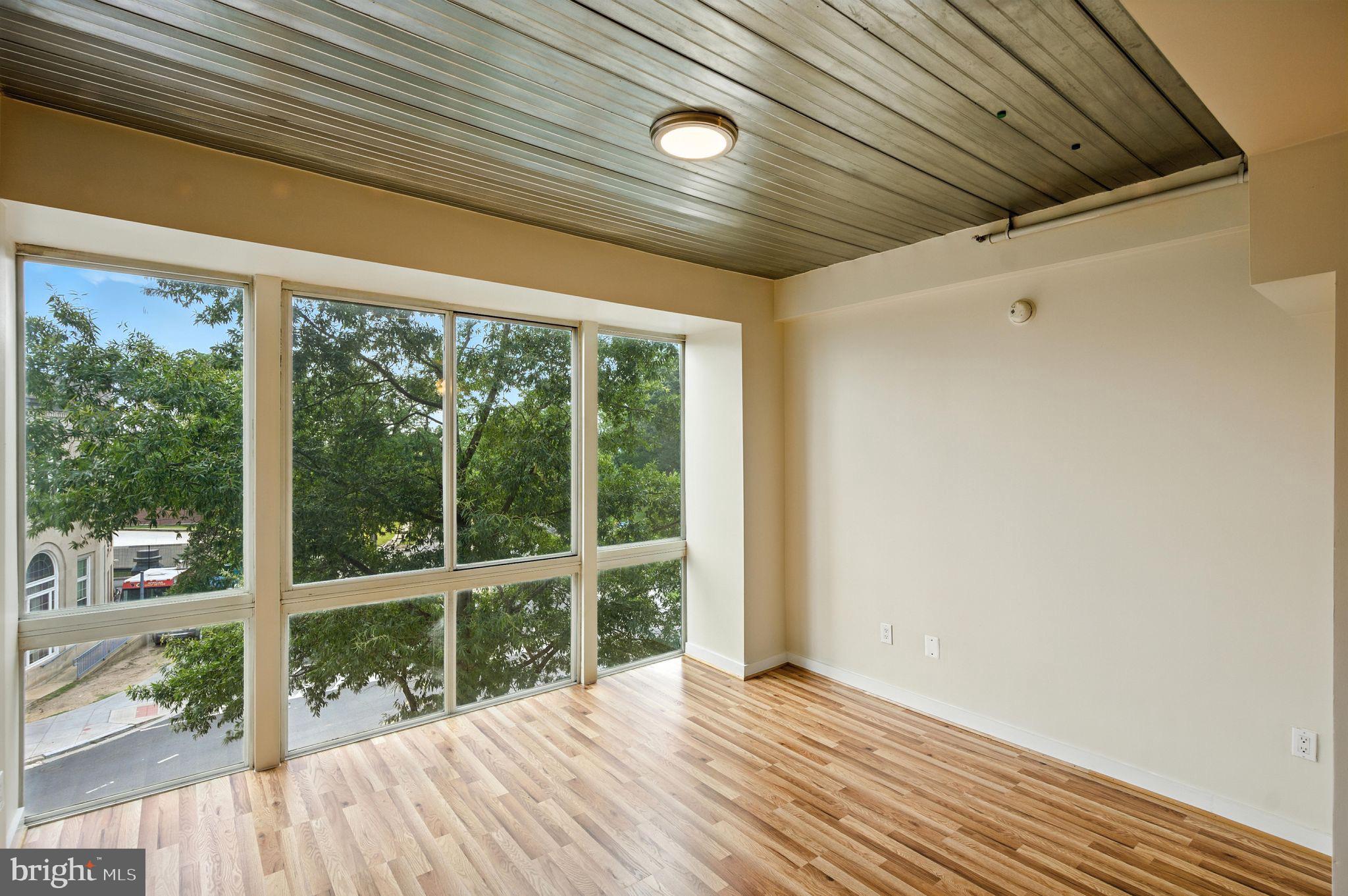 5885 Colorado Avenue Northwest, Unit 208 Washington, DC 20011 - Photo 8 of 27 a view of an empty room with wooden floor and outdoor view