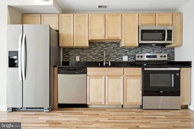 a kitchen with stainless steel appliances a stove microwave and refrigerator