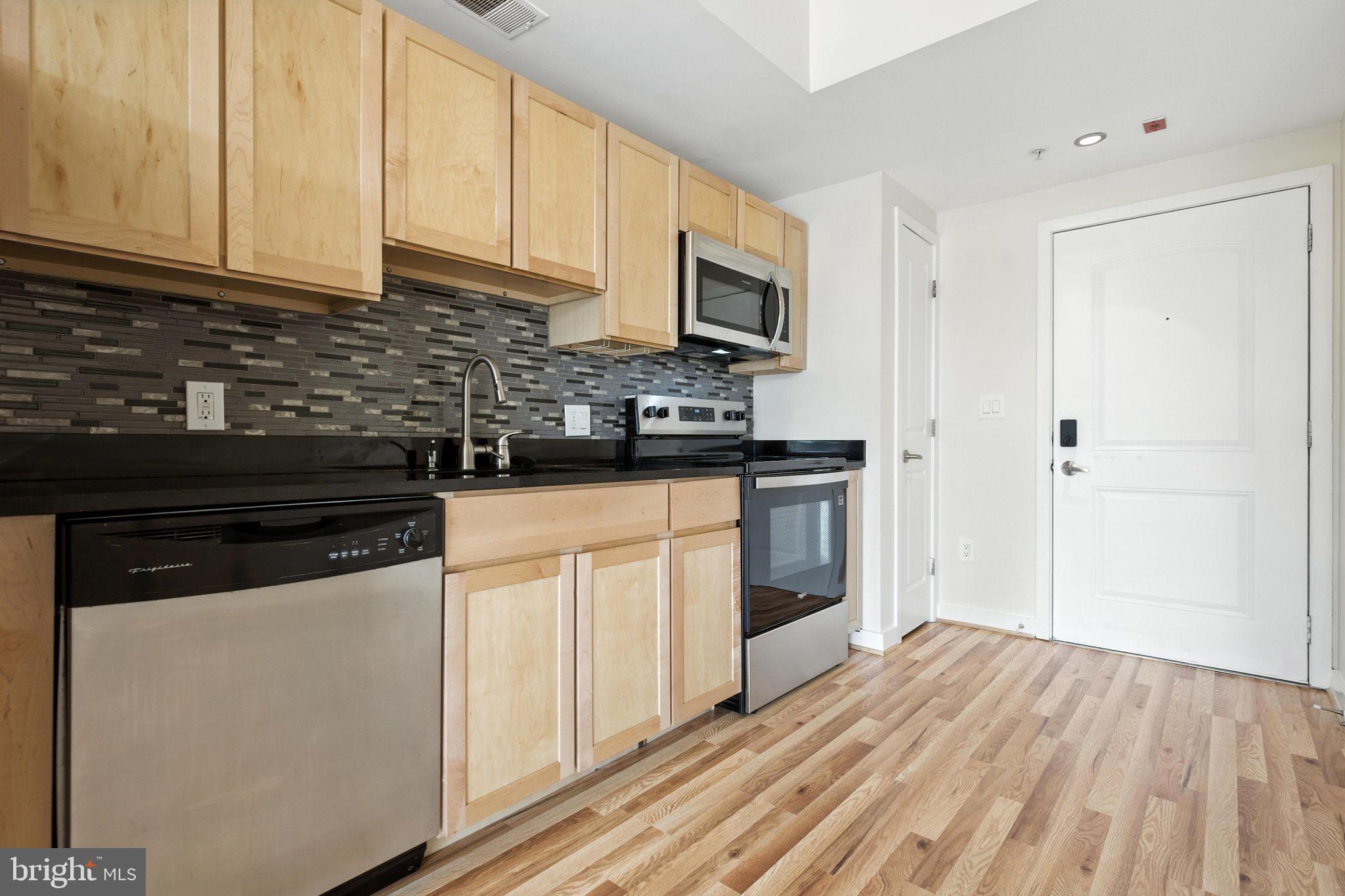 5885 Colorado Avenue Northwest, Unit 208 Washington, DC 20011 - Photo 10 of 27 a kitchen with stainless steel appliances granite countertop a stove a sink and a microwave