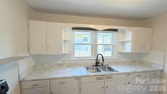 a kitchen with granite countertop a sink and a window