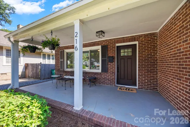a view of a house with outdoor seating and a garden