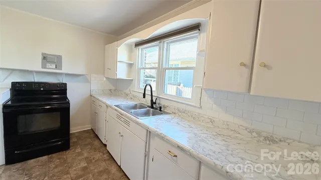 a kitchen with granite countertop a sink and a stove
