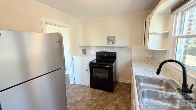 a kitchen with a refrigerator and a stove top oven