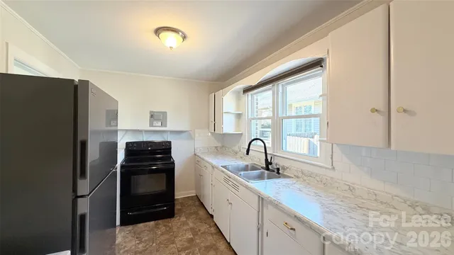 a kitchen with granite countertop a refrigerator and a sink