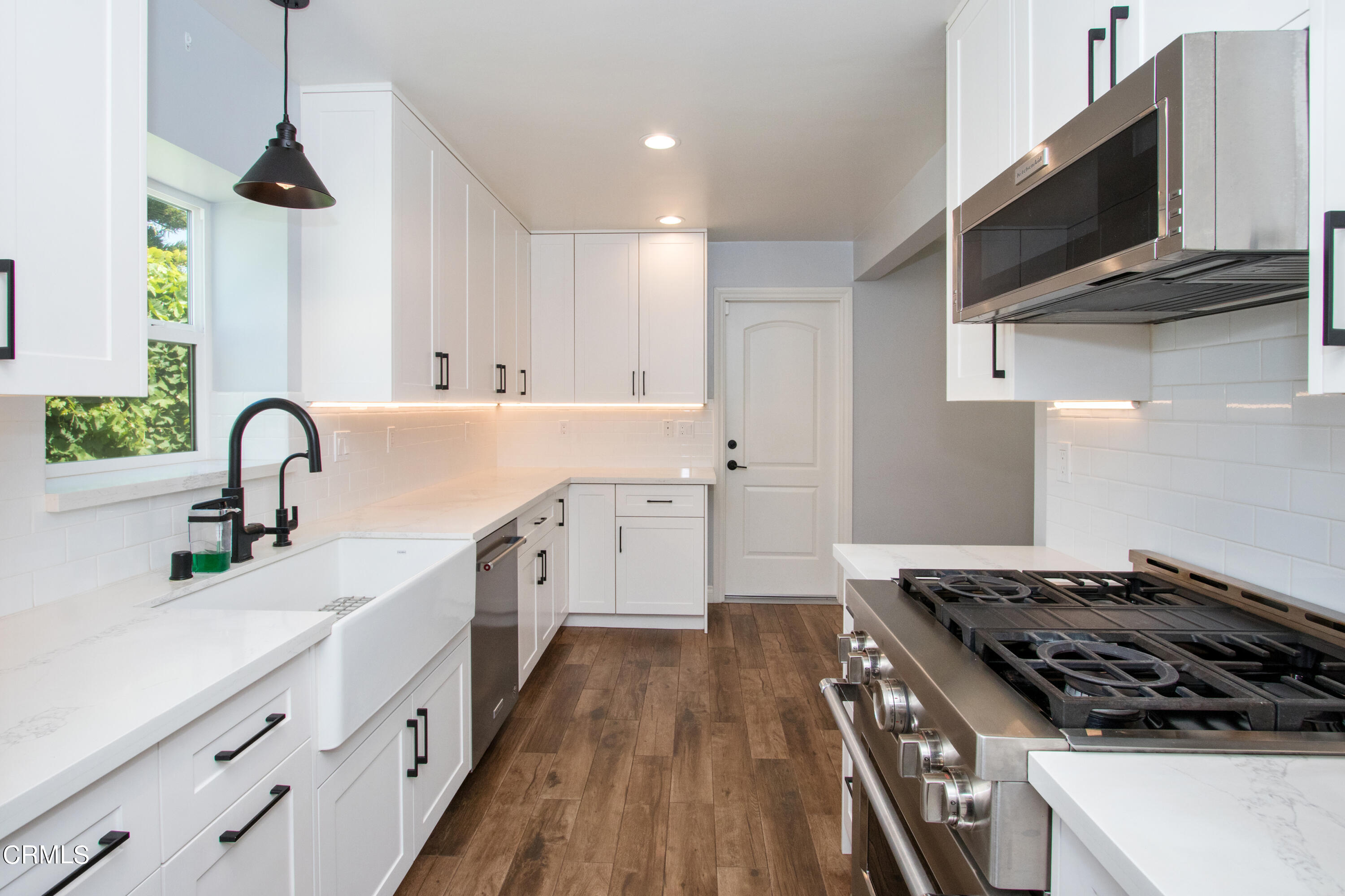 1029 Cynthia Avenue Pasadena, CA 91107 - Photo 6 of 19 a kitchen with stainless steel appliances a sink dishwasher a stove and a microwave oven with wooden floor