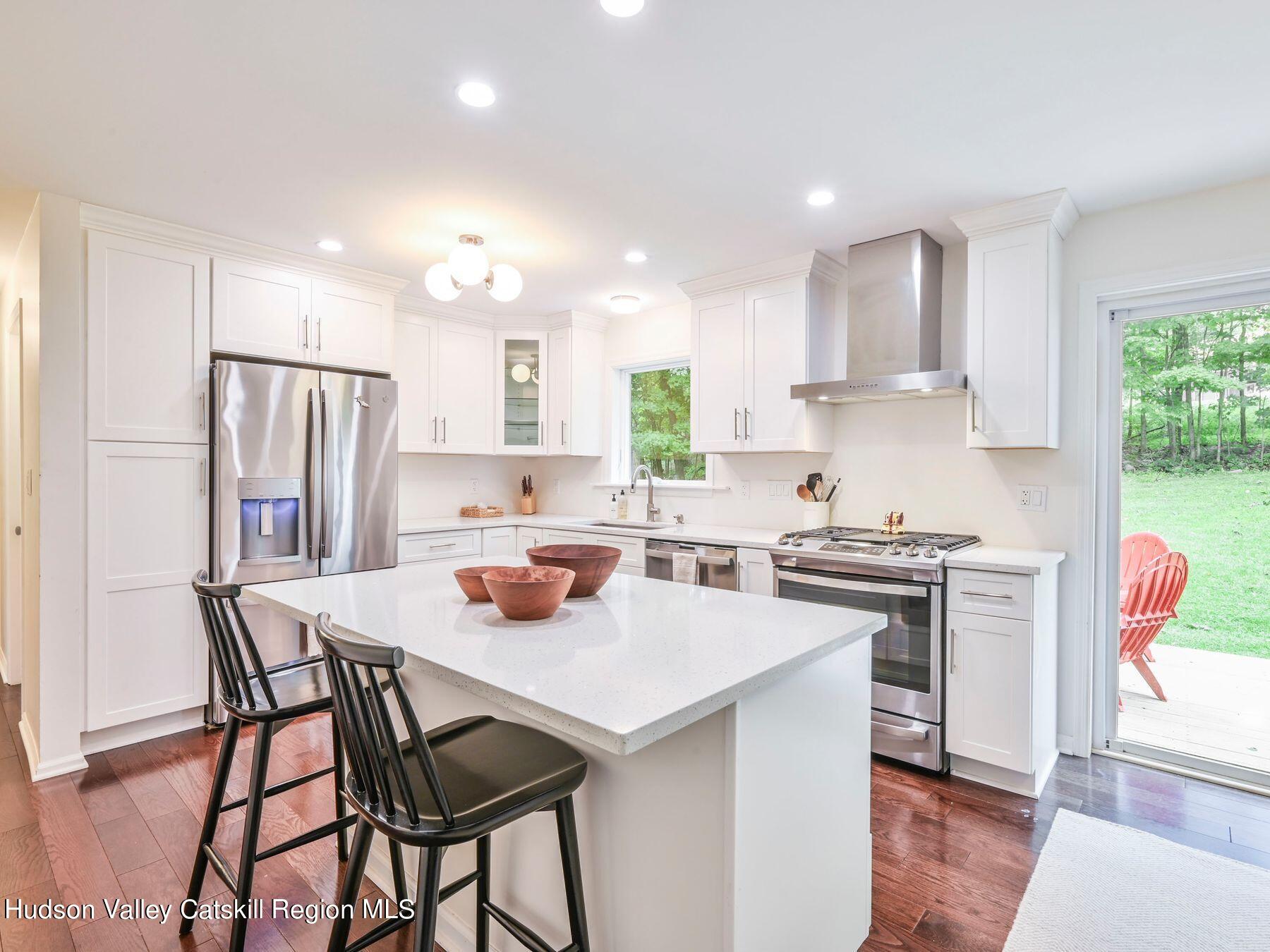 14 Red Maple Road Shokan, NY 12481 - Photo 14 of 34 a kitchen with stainless steel appliances granite countertop a stove a refrigerator a sink dishwasher a dining table and chairs with wooden floor