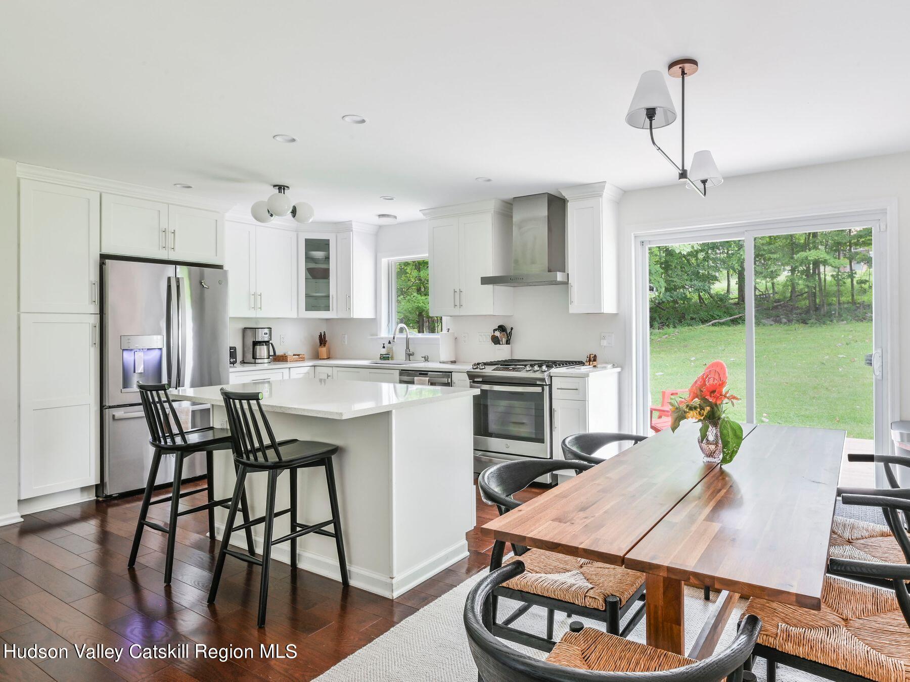 14 Red Maple Road Shokan, NY 12481 - Photo 10 of 34 a open kitchen with stainless steel appliances granite countertop a stove a refrigerator a kitchen island a table and chairs in it