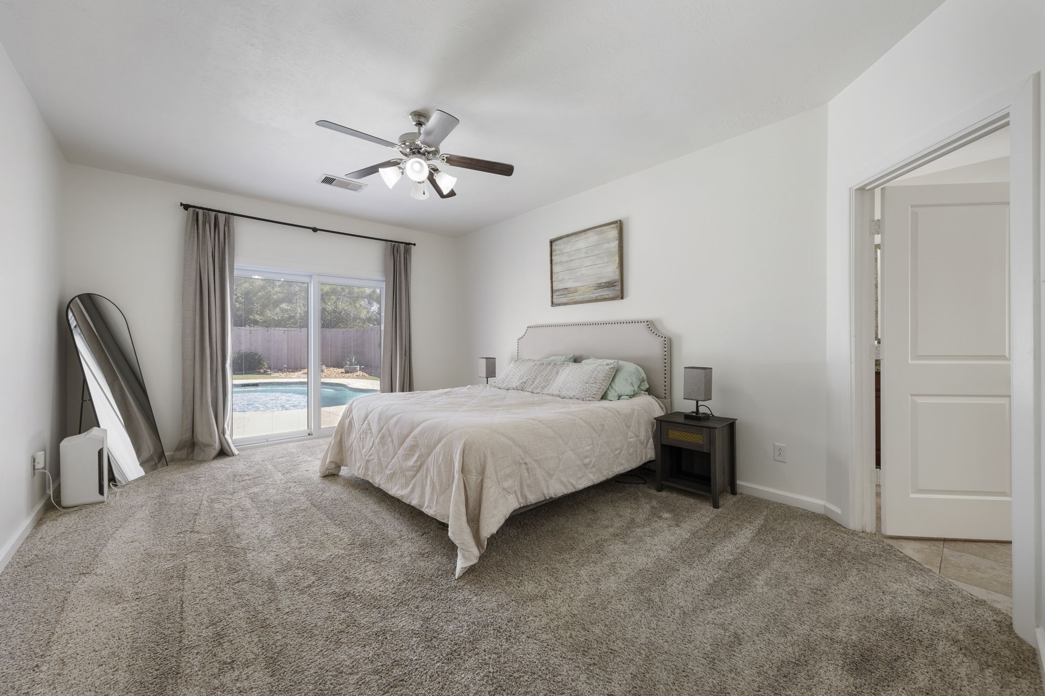3318 Solvista High Court Spring, TX 77386 - Photo 16 of 33 Thoughtfully designed primary bedroom provides a relaxing escape with oversized windows, plush carpeting, and sliding doors that lead directly this backyard paradise.