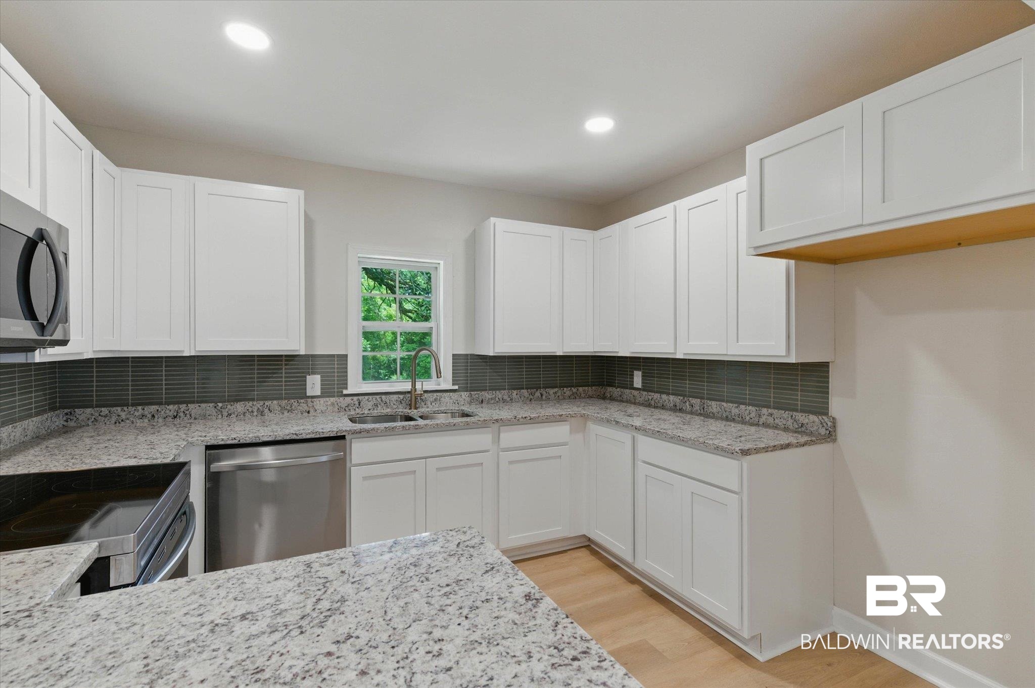 3512 Spring Hill Avenue Mobile, AL 36608 - Photo 7 of 20 Kitchen with stainless steel appliances, decorative backsplash, light wood-style flooring, white cabinets, and recessed lighting