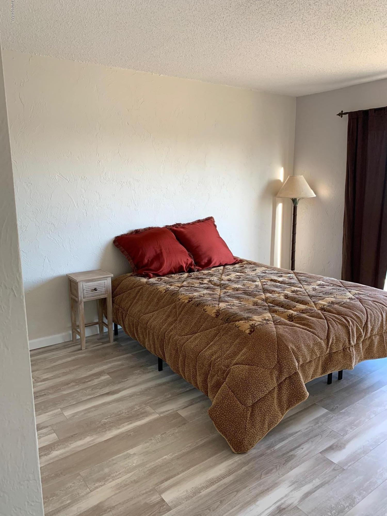 2250 Ocean Shore Boulevard, Unit 2030 Ormond Beach, FL 32176 - Photo 5 of 7 a bedroom with a bed and a lamp