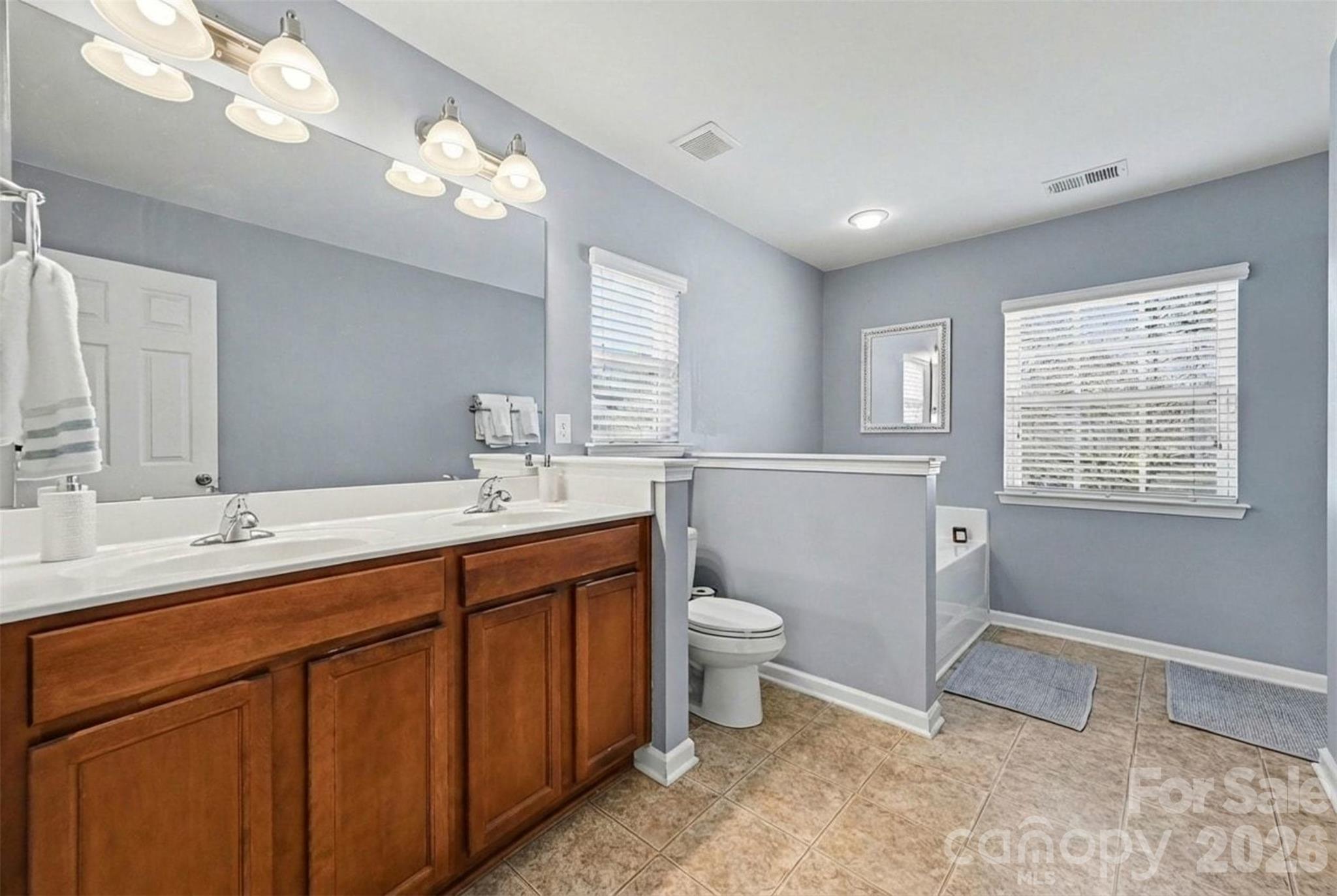 3009 Canopy Drive Indian Trail, NC 28079 - Photo 18 of 35 a spacious bathroom with a double vanity sink a toilet and a mirror