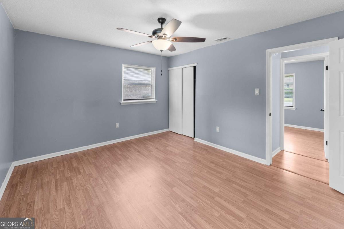 320 West Whatley Street Pooler, GA 31322 - Photo 17 of 34 a view of a big room with wooden floor and a ceiling fan