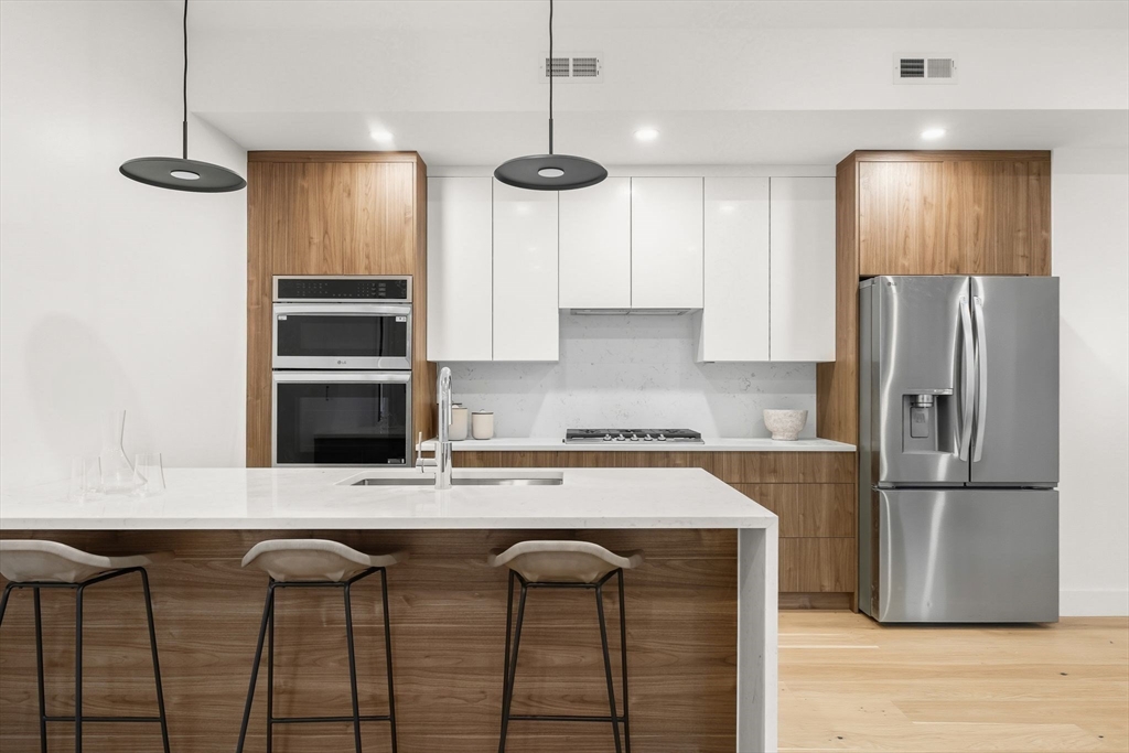 47 Condor Street, Unit 203A Boston, MA 02128 - Photo 2 of 15 a kitchen with stainless steel appliances granite countertop a sink a stove a refrigerator and island