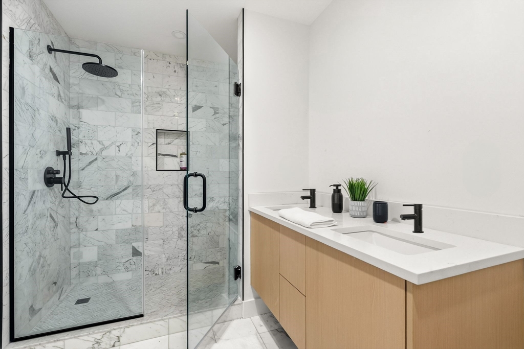 47 Condor Street, Unit 203A Boston, MA 02128 - Photo 8 of 15 a bathroom with a granite countertop shower a sink and a mirror
