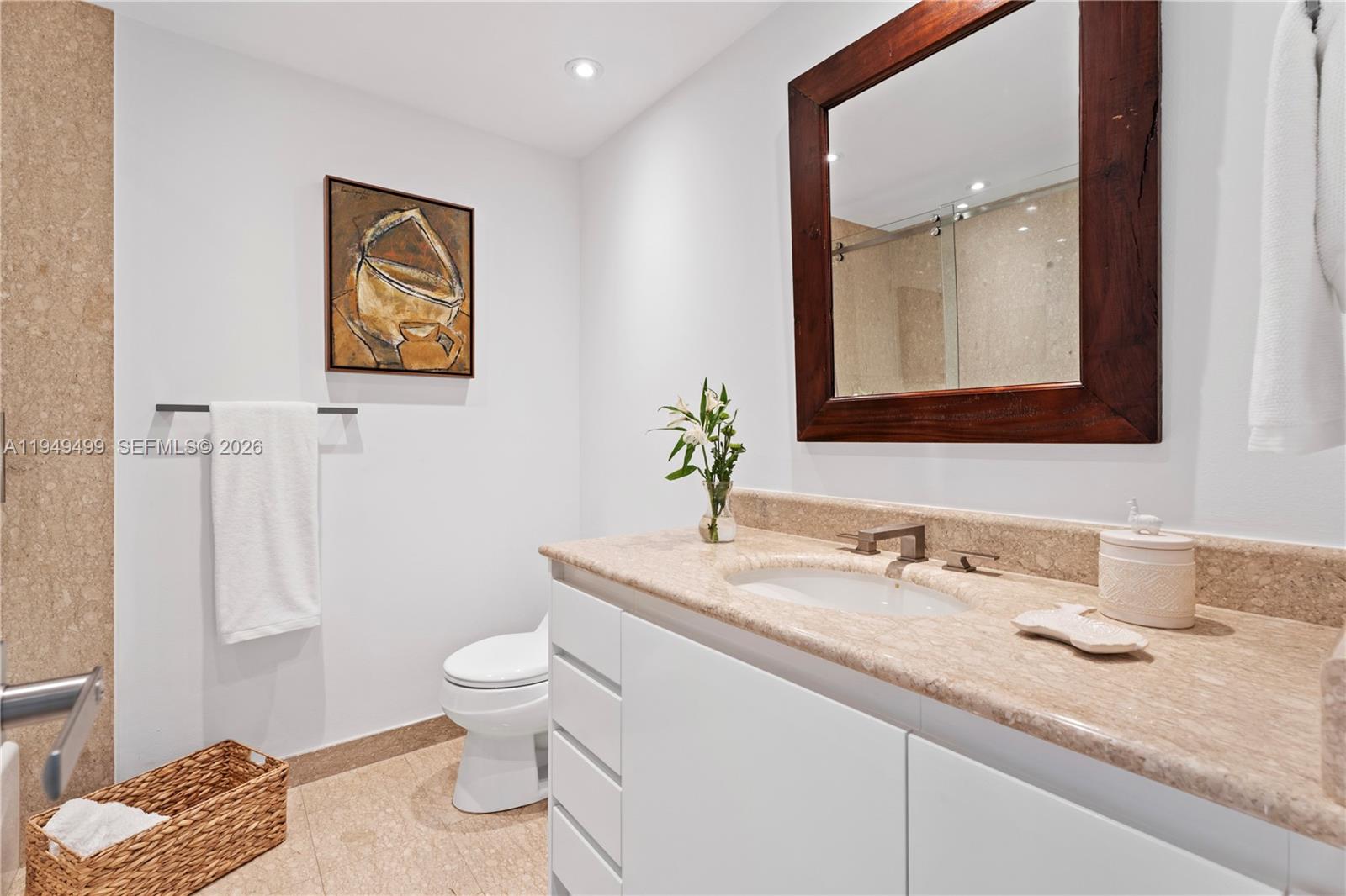 1643 Brickell Avenue, Unit 2506 Miami, FL 33129 - Photo 25 of 85 a bathroom with a granite countertop sink mirror and toilet