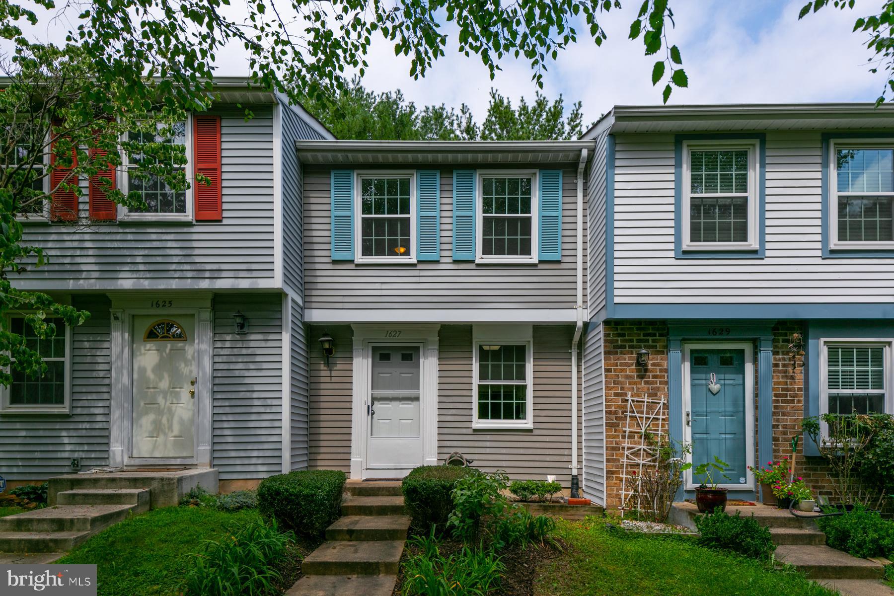 a front view of a house with plants