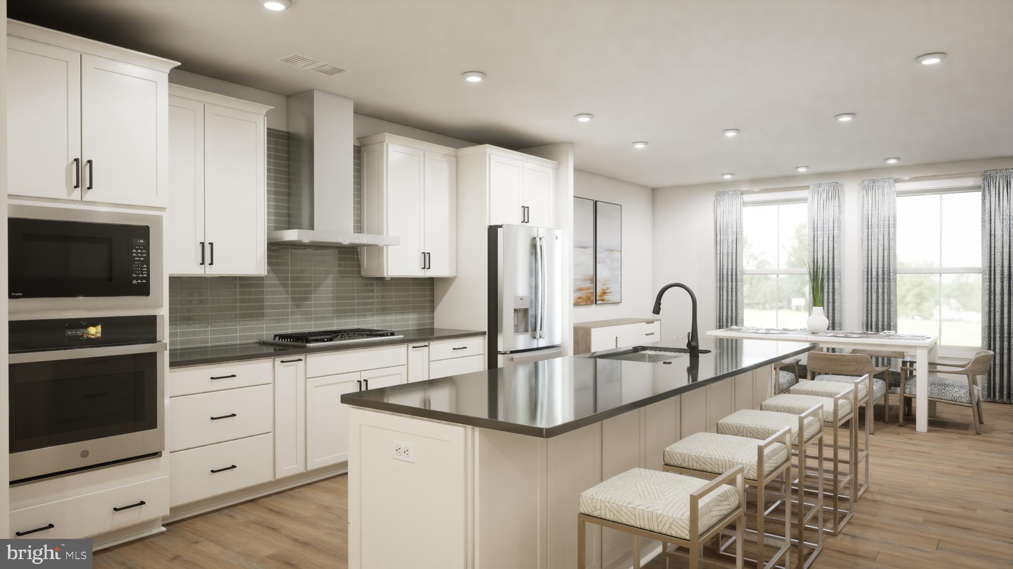 a large kitchen with granite countertop a sink and white cabinets