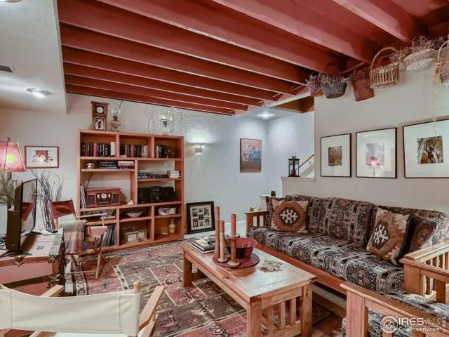 a living room with furniture a rug and a bookshelf