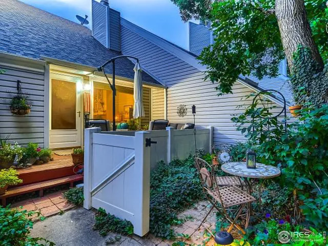a view of a patio with table and chairs potted plants and large tree