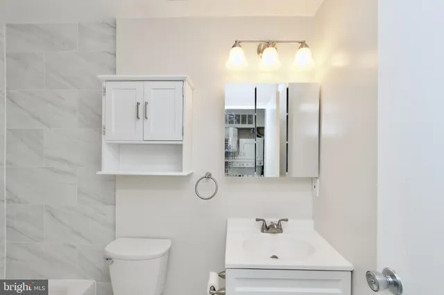 a bathroom with a sink mirror and toilet