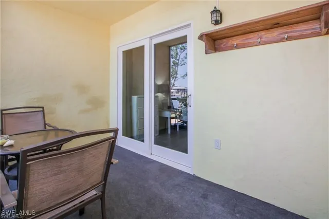 a view of a swimming pool with a table and chairs under an umbrella