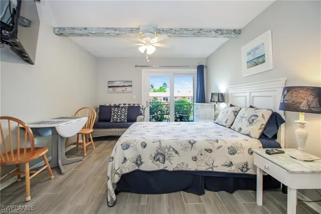 a bedroom with a bed a flat screen tv and a chandelier