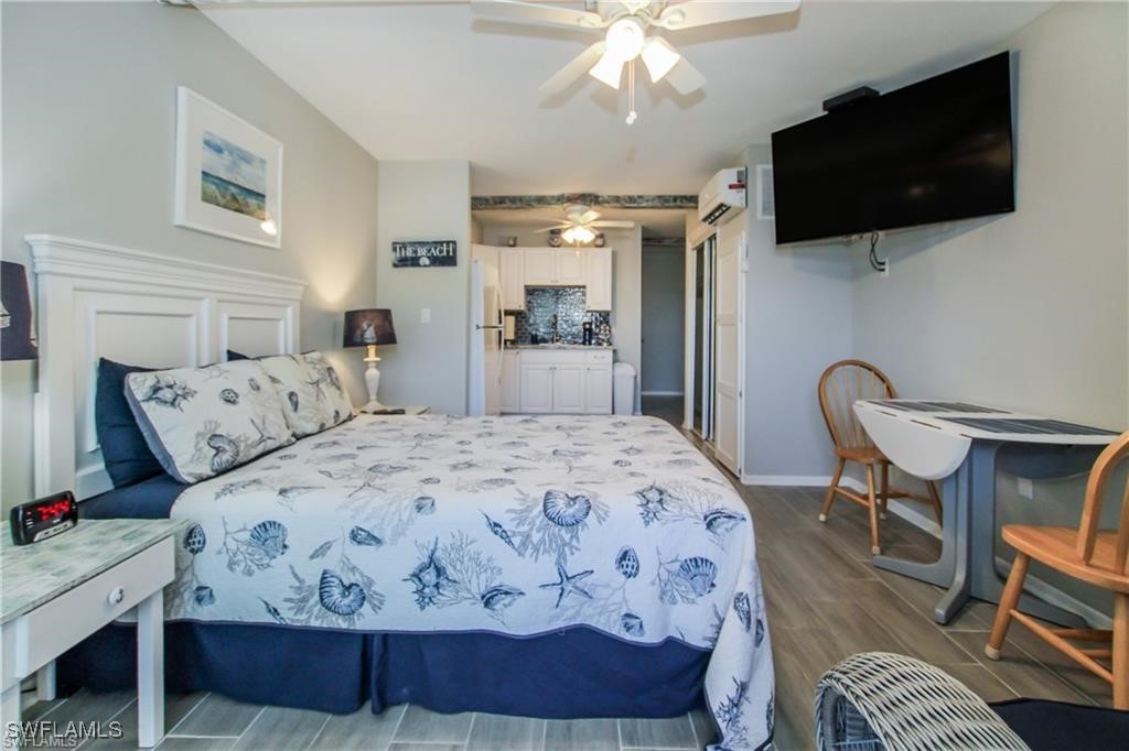 3226 Stringfellow Road St. James City, FL 33956 - Photo 10 of 28 a bedroom with a bed a flat screen tv and a chandelier