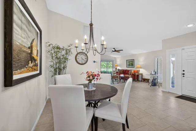 a view of a dining room and livingroom with furniture wooden floor a chandelier