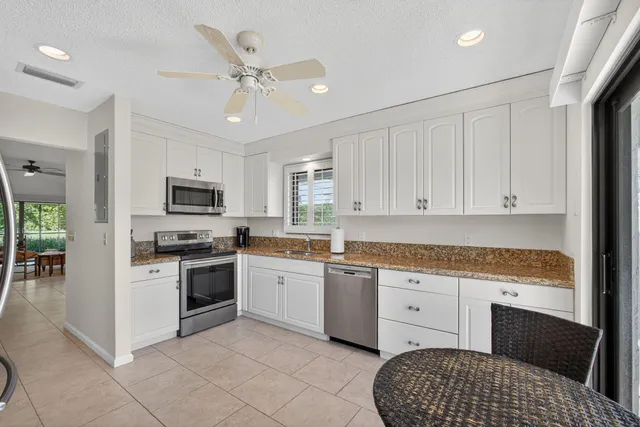 a kitchen with stainless steel appliances granite countertop a stove sink and cabinets