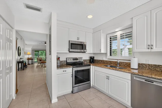 a kitchen with cabinets stainless steel appliances and a window