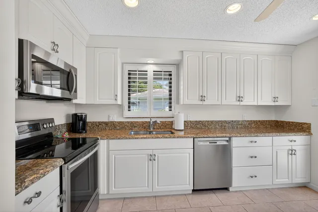 a kitchen with white cabinets stainless steel appliances and sink