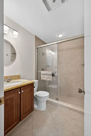 a bathroom with a granite countertop sink toilet and shower