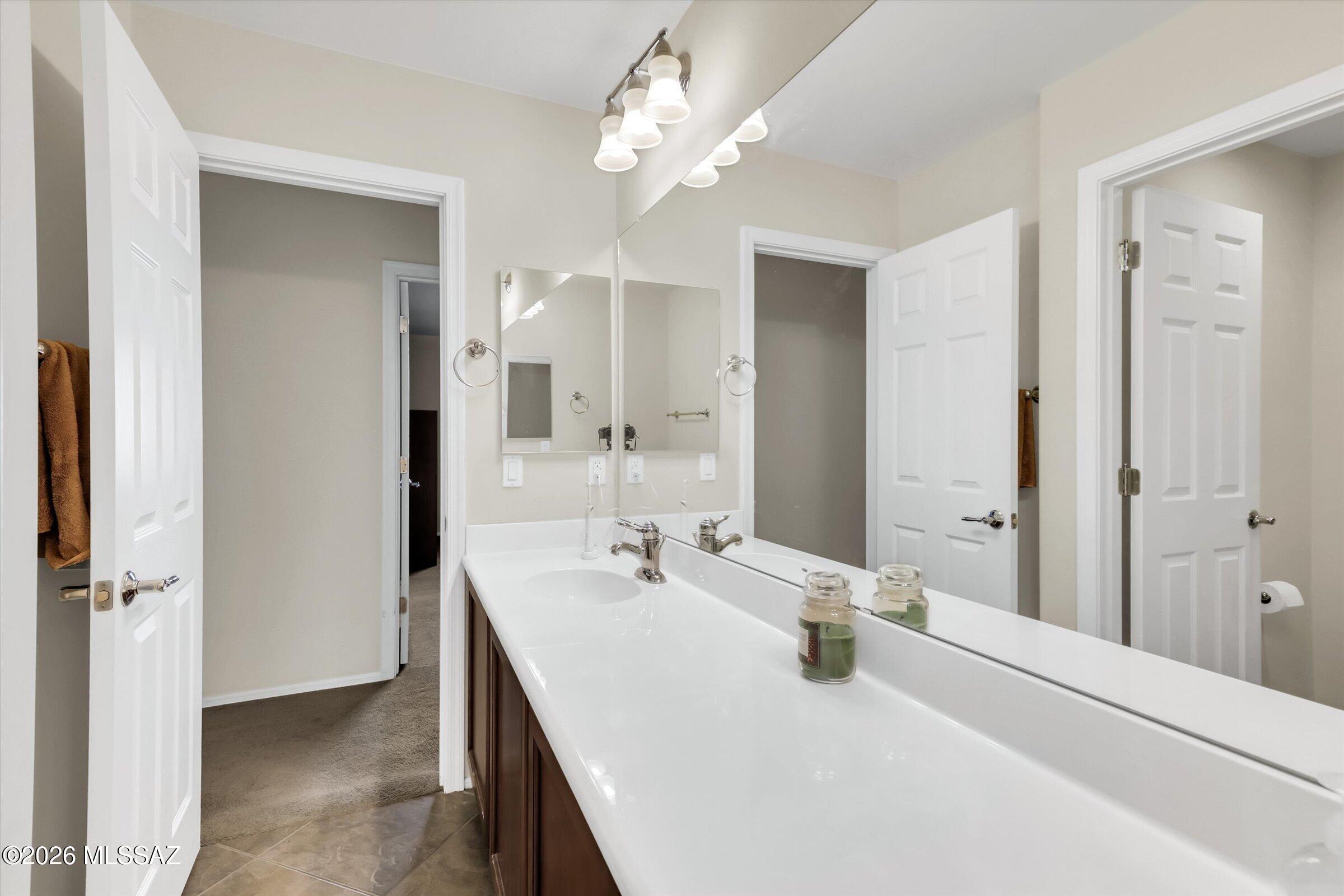 6095 South Jakemp Trail Tucson, AZ 85747 - Photo 37 of 52 a bathroom with a sink a mirror and a shower