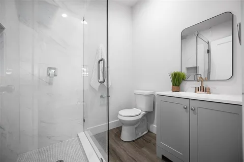 a bathroom with a sink a toilet and shower